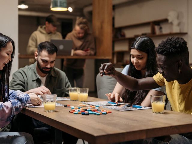 Friends playing a board game around a table